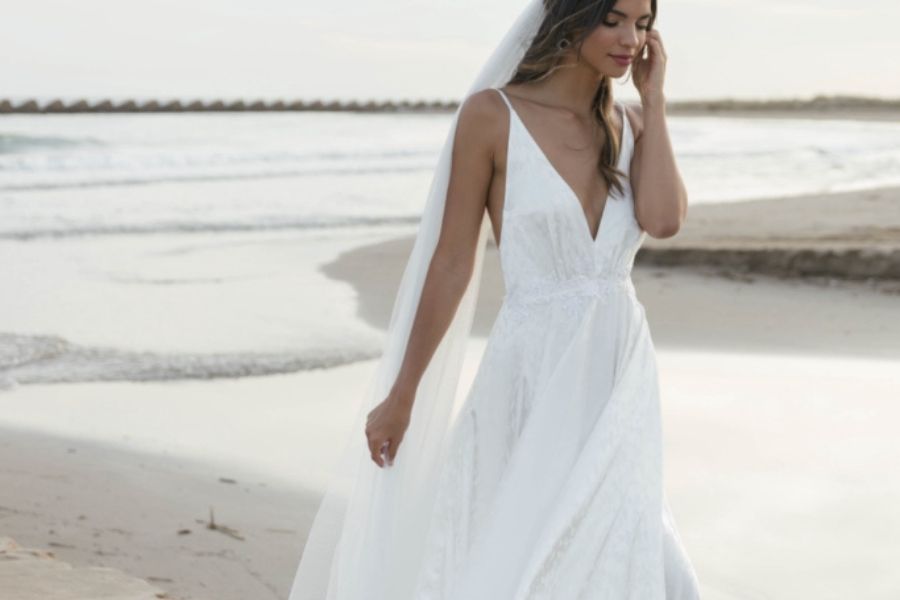 chica vestida de novia pasea por la playa