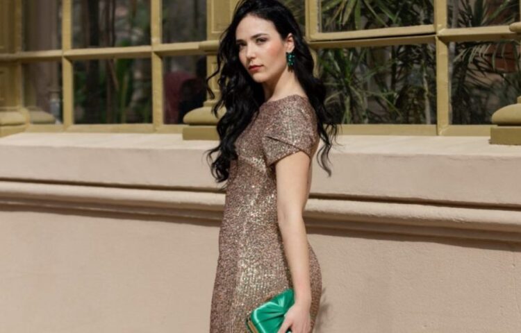 chica luce vestido con brillante y un bolso verde