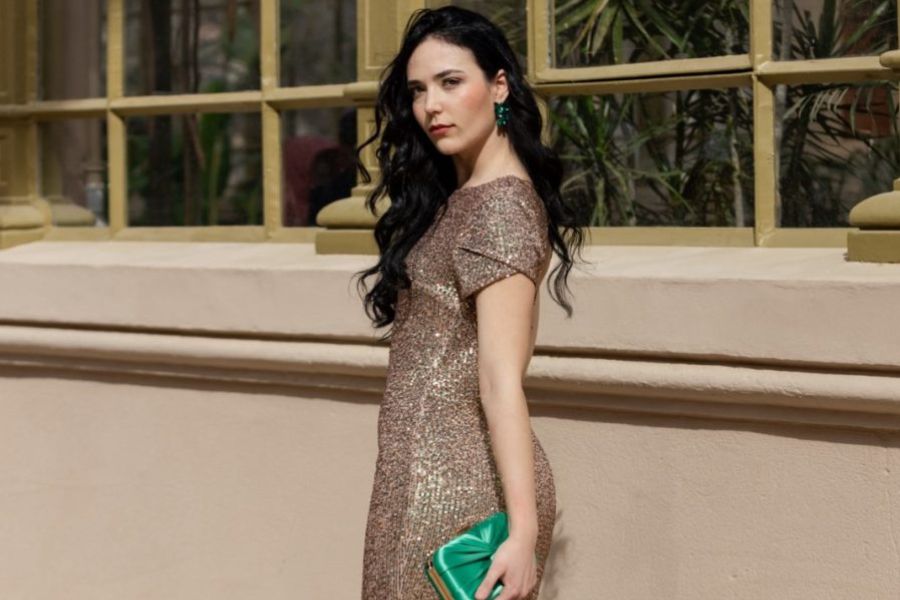 chica luce vestido con brillante y un bolso verde